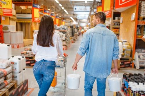 Preview: Happy buyers with a cart in hardware store
