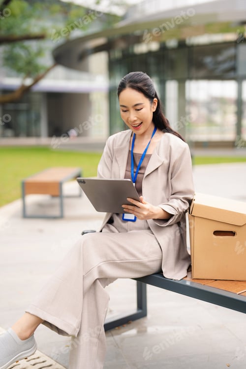 Preview: woman analyzing financial stats and graphs on paperwork in front of a modern office building.