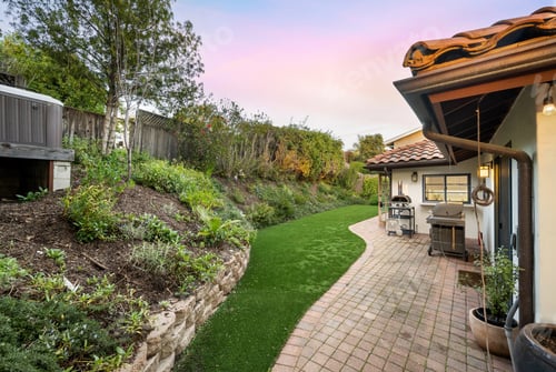 Preview: Backyard featuring a charming patio with a BBQ grill and verdant lawn