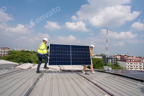 Preview: Team technicians carrying photovoltaic solar moduls on roof.