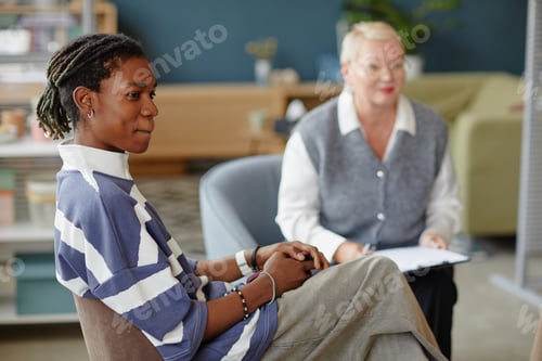 Preview: Young Black Man Attending Counseling Session with Middle Aged Caucasian Woman