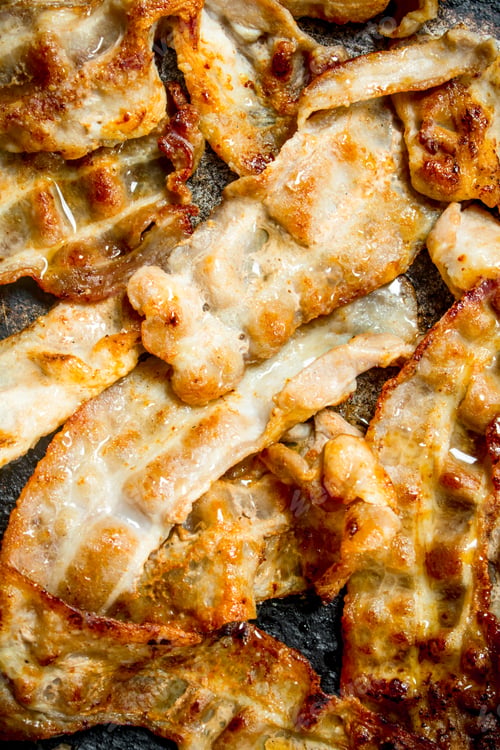 Preview: Fried bacon in a frying pan.
