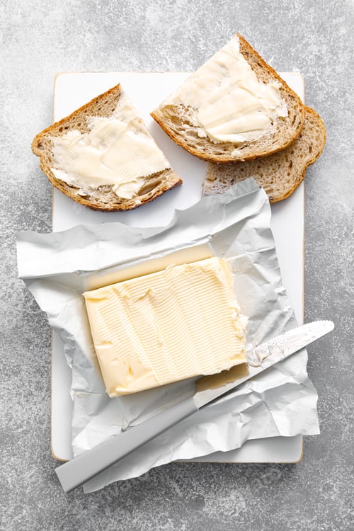 Preview: Block of butter with butter knife in a open pack. Buttering bread