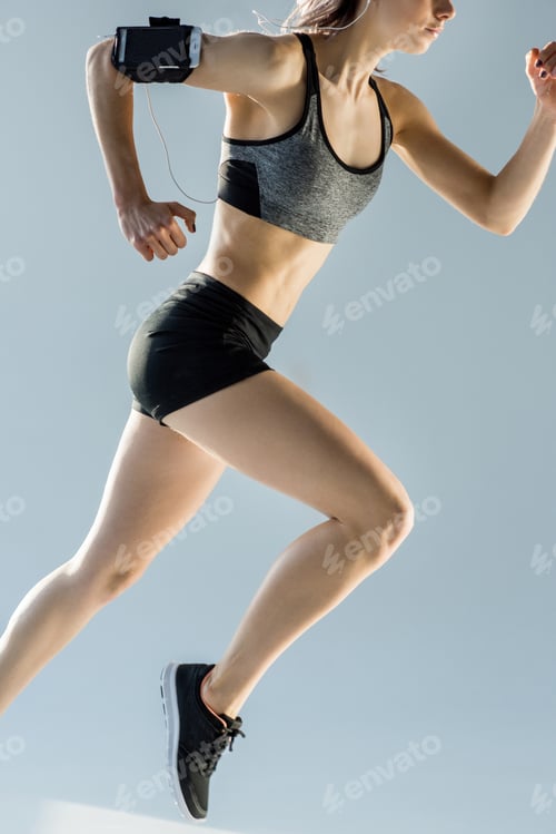 Preview: side view of running sporty woman isolated on grey