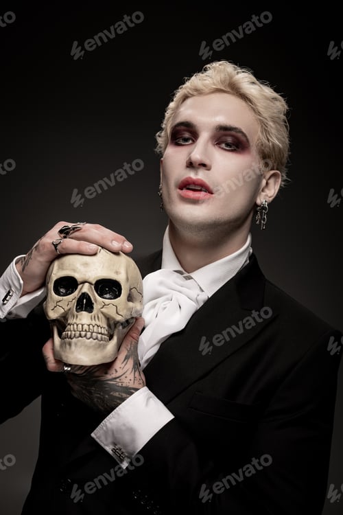 Preview: Young man showcases stunning Halloween costume with a skull prop for an extraordinary celebration