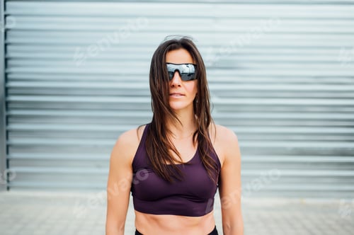 Preview: Portrait of beautiful woman ready for workout in the street. Sport training concept.