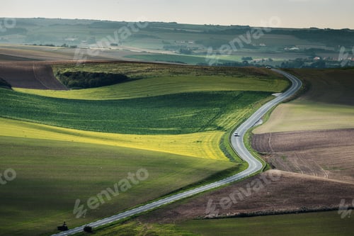 Preview: High angle shot of a narrow freeway in the middle of a green field