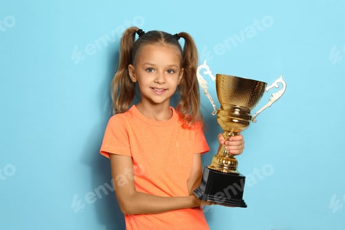 Preview: Happy girl with golden winning cup on blue background