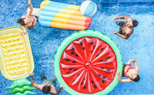 Preview: Happy friends playing with ball inside swimming pool