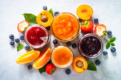Preview: Homemade jam in glass jars at white table.