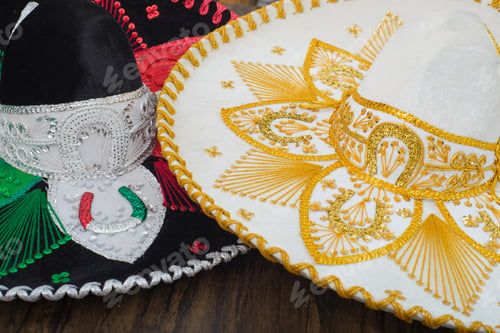 Preview: Mexican charro hats on wooden table. Mariachi hats. Typical mexican sombreros.