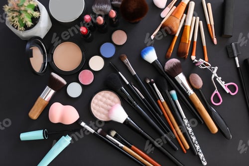 Preview: Flat lay composition with makeup brushes and cosmetic products on black background