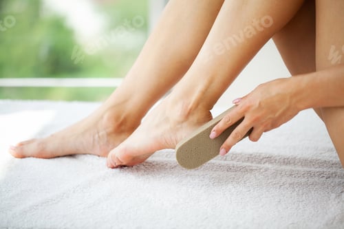 Preview: Woman cleans the heel of the foot with pumice
