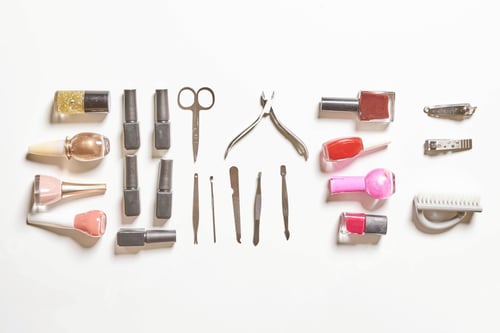 Preview: Top view of stylish manicure accessories with gel nail polishes, and scissors on white surface