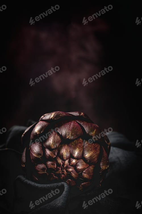 Preview: Fresh raw purple artichokes. On dark background.