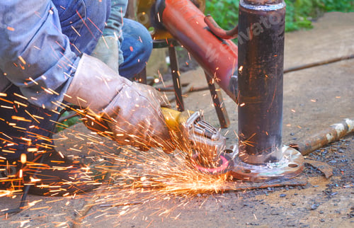 Preview: Welder hand using electric grinder machine to polishing metal flange on steel tube