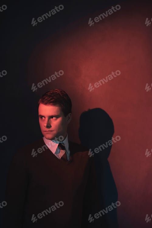 Preview: Man In White Shirt And Brown Sweater In Red Light.