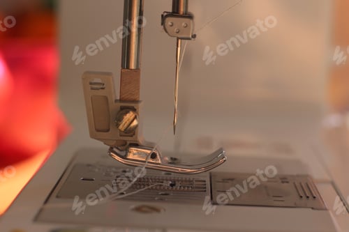 Preview: Closeup shot of a sewing machine needle with its foot seen in profile