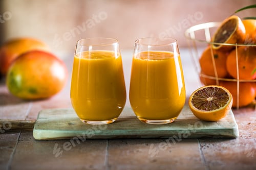 Preview: Two mango lassi or kesar milk in glasses. Indian healthy ayurvedic cold drink with mango.