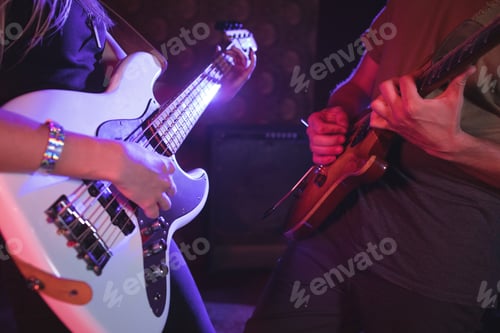 Preview: Mid section of male and female guitarist in nightclub