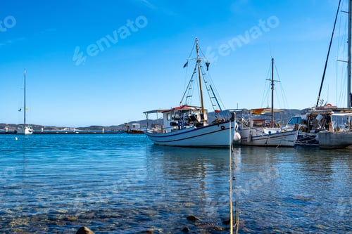Preview: Fishing boat moored at Koufonisi Greek island port dock. Cyclades, Aegean sea, blue sky background.