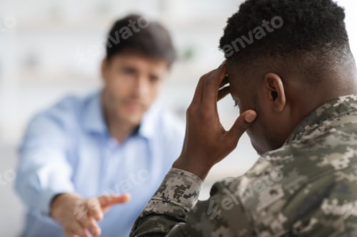 Preview: Unrecognizable psychotherapist outstretching hand towards upset soldier