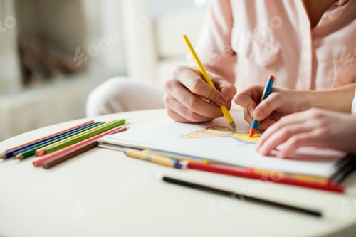 Preview: partial view of mother and daughter drawing picture together