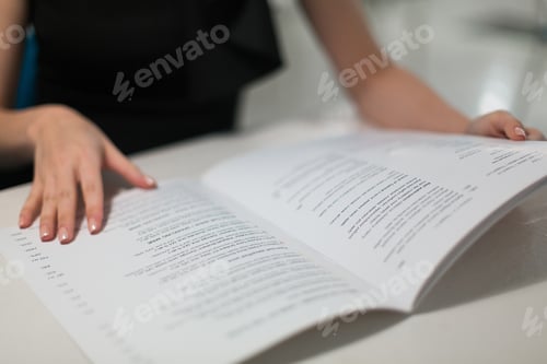 Preview: A young woman in a restaurant reads the menu and chooses dishes. Runs his finger across the paper.