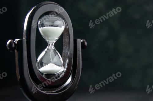 Preview: front view of black hourglass on the dark surface funeral evil israel war death time