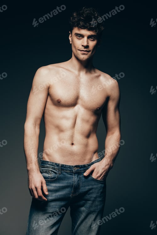 Preview: handsome shirtless man in jeans posing isolated on dark grey