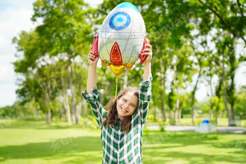 Preview: Portrait of red hair kid in pilot costume holding bolloon running in summer field