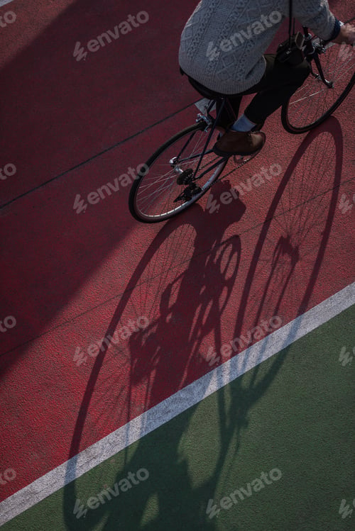Preview: high angle view of man riding bicycle on freshly painted biking road