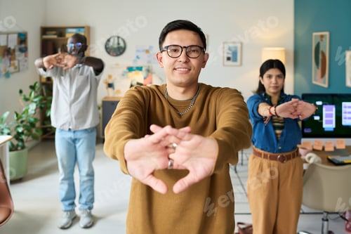 Preview: Multiethnic Adults Stretching Arms Together during Office Break