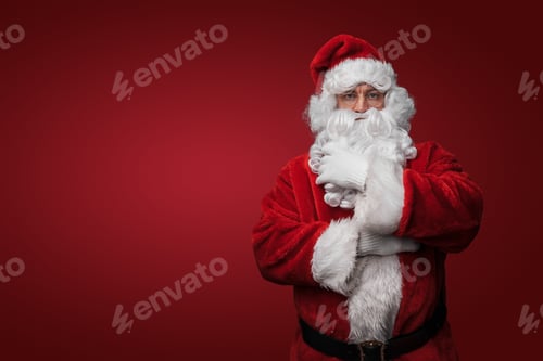 Preview: Christmas santa stroking his beard against gray background