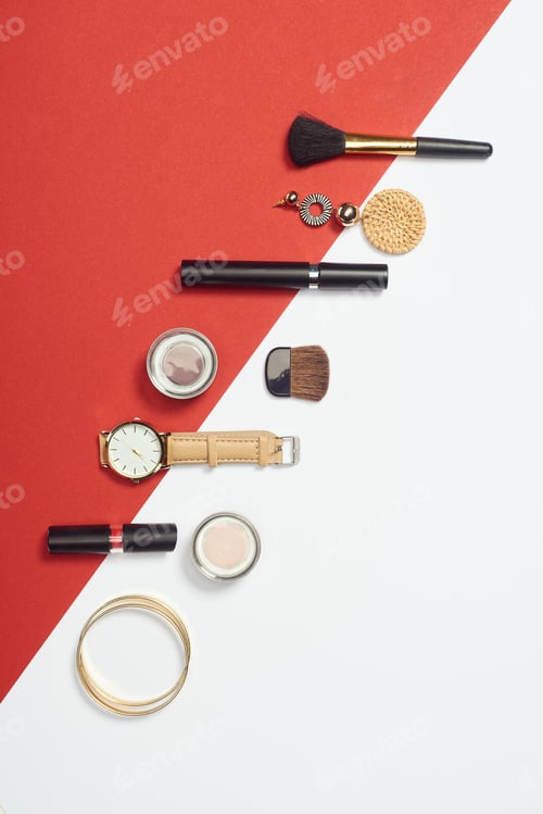 Preview: Flat lay with mascara, watch, bracelets, eyeshadow, lipstick, earring and cosmetic brushes