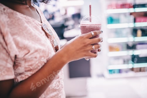 Preview: Refreshing Pink Smoothie Held in a Store