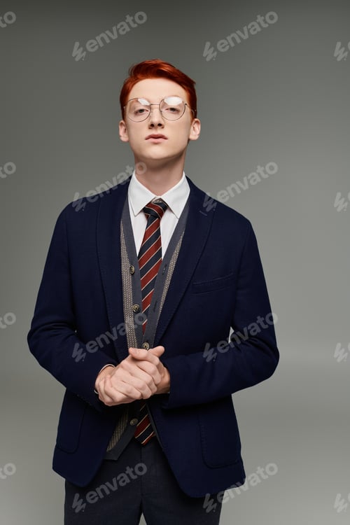 Preview: Stylish young student with red hair in elegant winter attire posing confidently in a studio