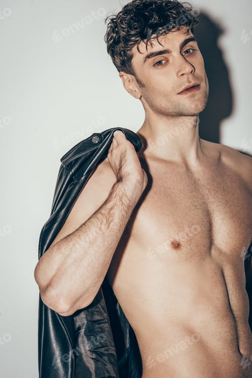 Preview: sexy macho posing with black leather jacket on grey
