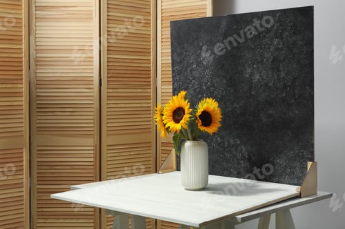 Preview: Vase with beautiful sunflowers and double-sided backdrop on table in photo studio