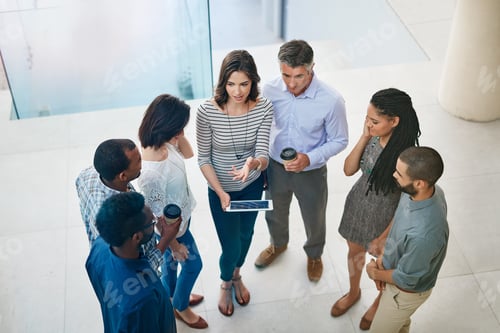 Preview: Many hands make light work. High angle shot of businesspeople talking in the lobby of their office.
