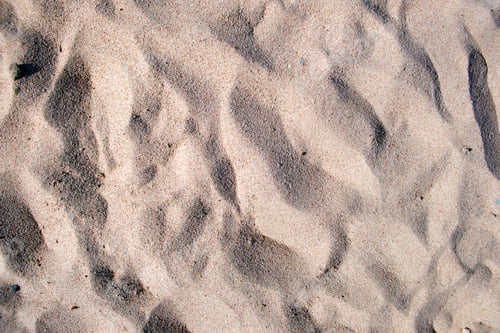 Preview: Flat view of clean yellow sand surface covering seaside beach. Sandy texture