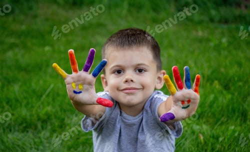 Preview: Children's hands in the colors of summer, a smile on the boy's palm