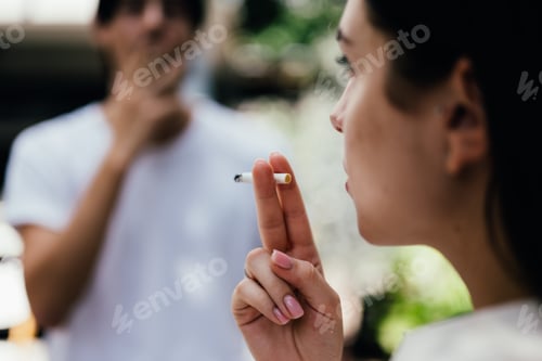 Preview: Young couple of man and woman smoking cigarette together