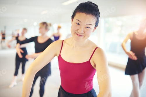 Preview: Smiling Asian ballerina looking at camera in class