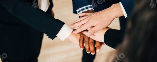 Preview: An above view of a diverse business group holding hands in a circle. This act of teamwork and