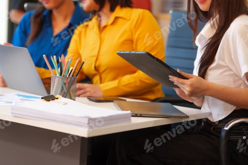 Preview: A young Asian startup business team collaborating on a project in a modern office, using a laptop