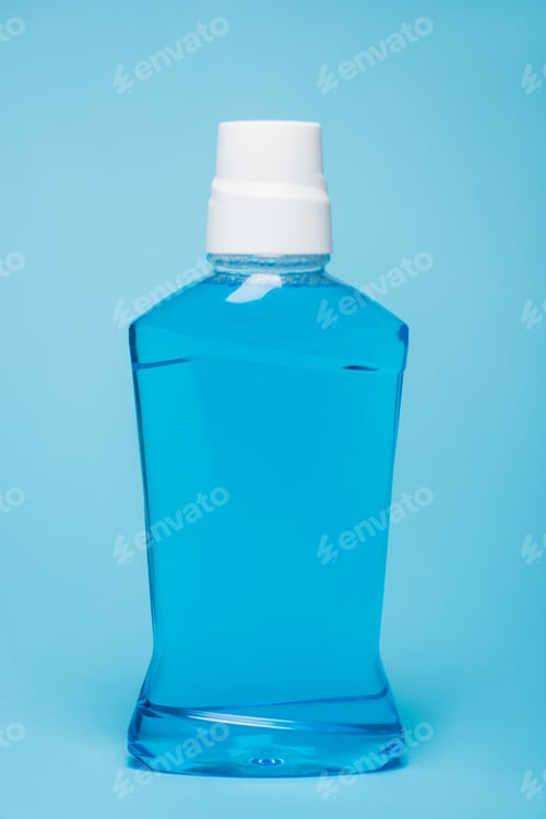 Preview: Bottle of mouthwash with white cap on blue background
