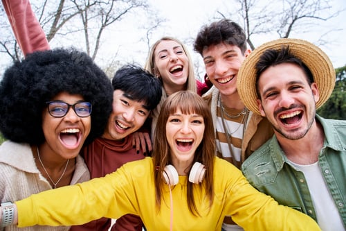Preview: Multiracial group of happy friends taking a selfie in an urban park. Big smiles and good times.