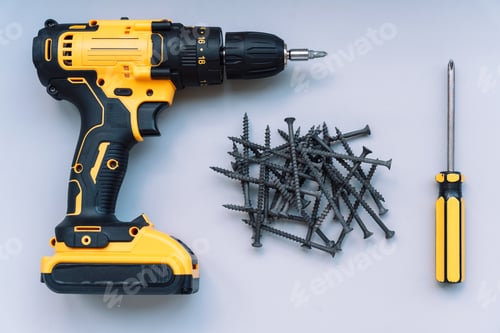 Preview: Screws lie on a gray background with a screwdriver and an electric screwdriver