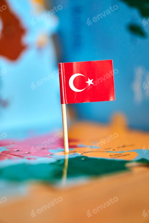 Preview: Closeup of a flag of Turkey with a small stick on the map